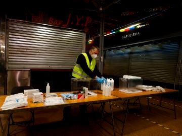 Un operario prepara una mesa electoral de cara a las elecciones en Cataluña del 14 de febrero
