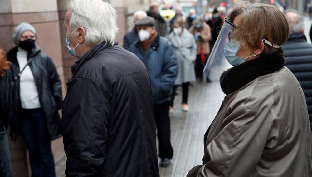 Dos personas mayores esperan su turno para votar en Cataluña.