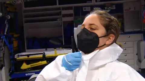 Miembro de una mesa electoral colocándose un EPI Miembro de una mesa electoral colocándose un EPI