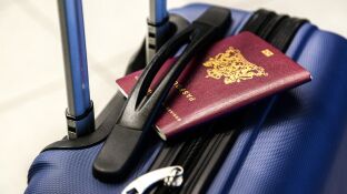 Imagen de archivo de un pasaporte y una maleta
