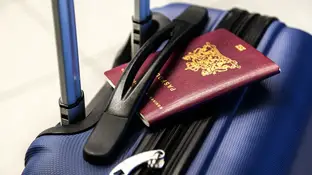 Imagen de archivo de un pasaporte y una maleta Imagen de archivo de un pasaporte y una maleta