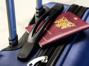 Imagen de archivo de un pasaporte y una maleta Imagen de archivo de un pasaporte y una maleta