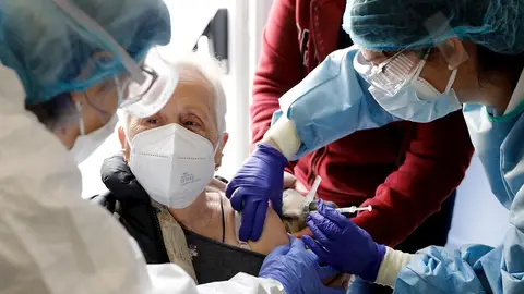 Dos sanitarias vacunan a una anciana en una residencia Dos sanitarias vacunan a una anciana en una residencia