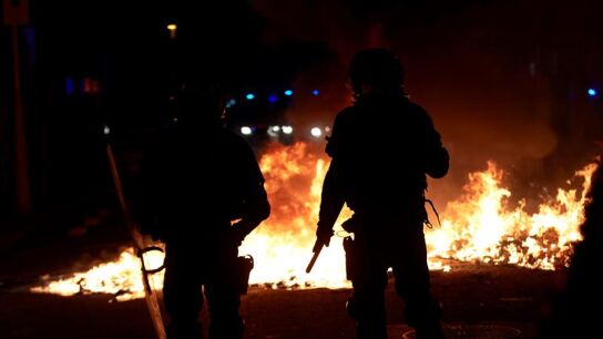Agentes de los Mossos junto a una barricada en llamas en la Calle Arag&oacute;
