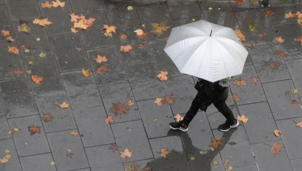 Imagen de archivo de una persona caminando bajo la lluvia