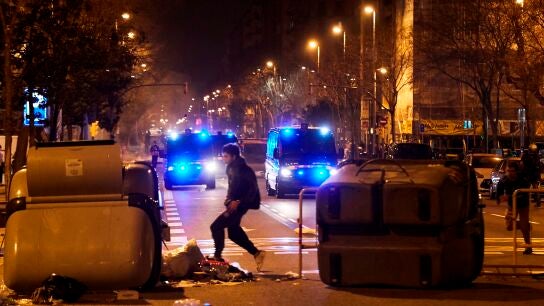 Manifestantes y polic&iacute;as junto a una barricada en las protestas en Barcelona