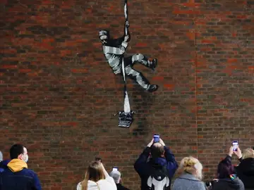 Un grupo de personas toma fotos del nuevo grafiti de Banksy de la prisión inglesa de Reading Un grupo de personas toma fotos del nuevo grafiti de Banksy de la prisión inglesa de Reading