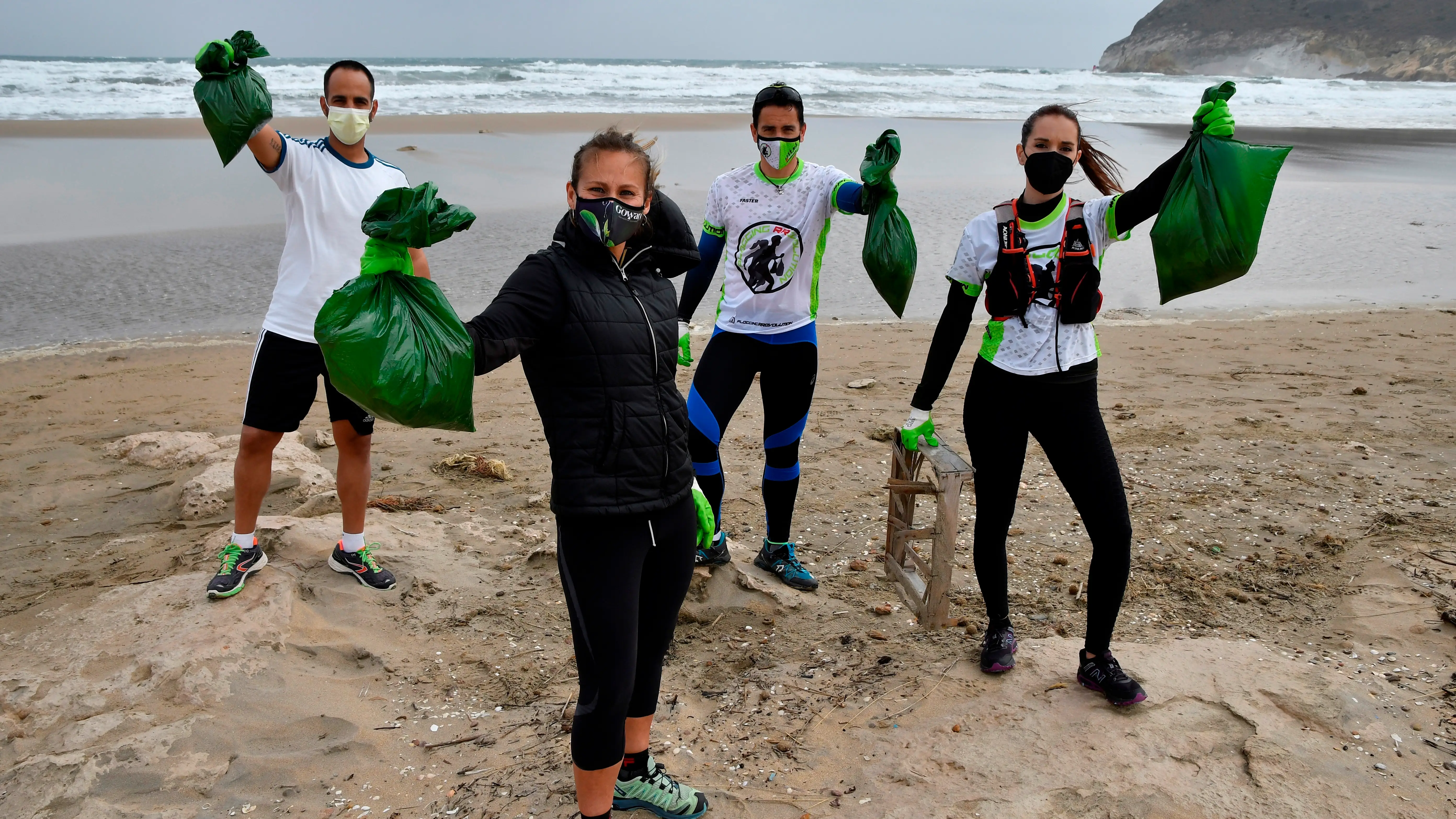 Miembros del grupo "Plogging RRevolution" recogiendo basura en una playa Miembros del grupo "Plogging RRevolution" recogiendo basura en una playa