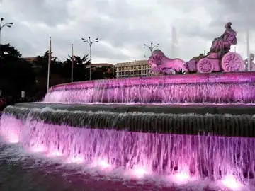 Imagen de la la Plaza de Cibeles teñida de morado Imagen de la la Plaza de Cibeles teñida de morado