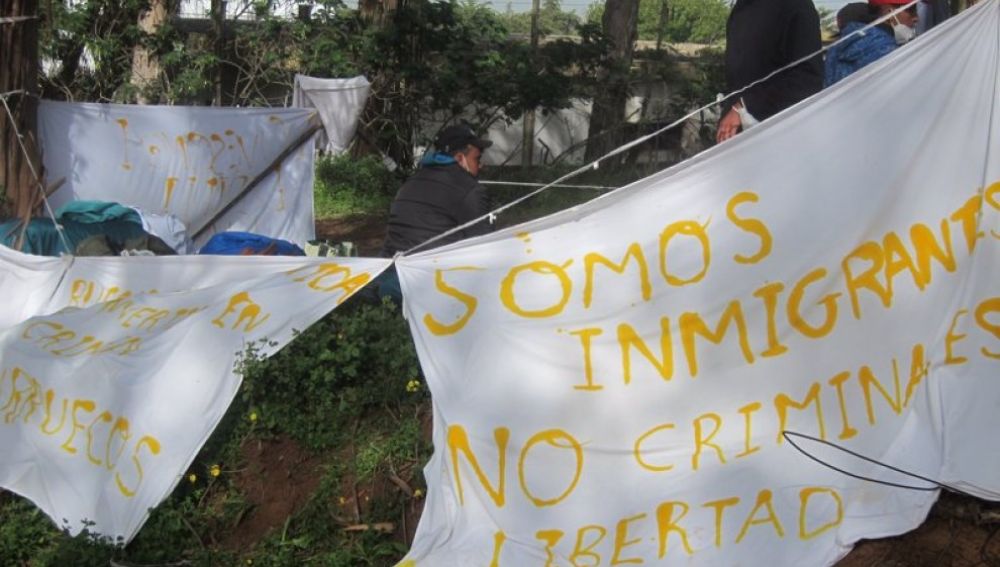 Pancartas de inmigrantes en el campamento Las Raíces de Tenerife