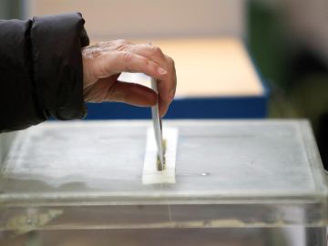 Una persona deposita su voto en una urna