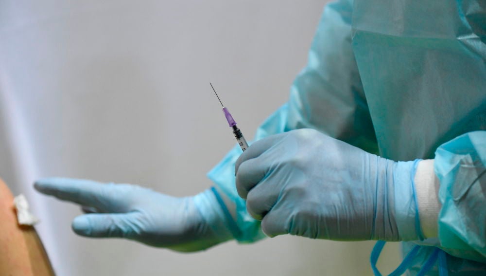 Un sanitario se prepara para administrar una dosis contra el coronavirus