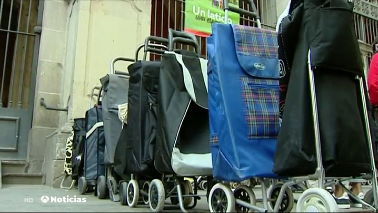 Filas de carros de la compra para recibir ayuda en una Iglesia en las colas del hambre de Barcelona