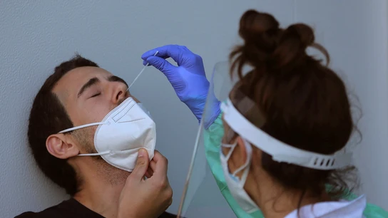 Personal sanitario realizando una PCR a una persona Personal sanitario realizando una PCR a una persona