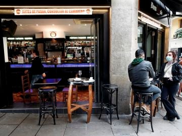  Dos personas toman un aperitivo en el exterior de un bar de Pamplona