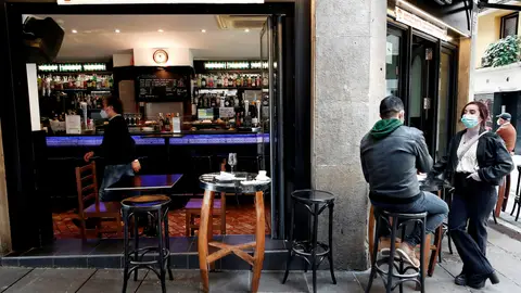 Dos personas toman un aperitivo en el exterior de un bar de Pamplona Dos personas toman un aperitivo en el exterior de un bar de Pamplona