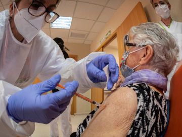 Sanitario vacuna a una persona mayor