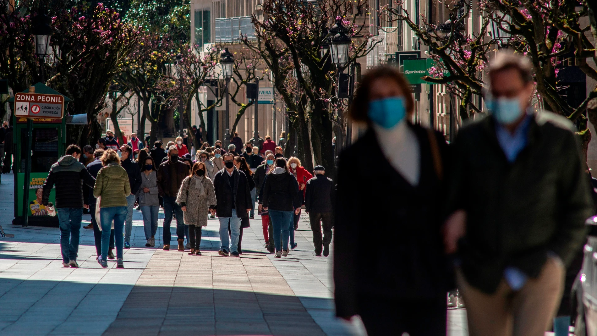 Gente camina por el Paseo de Ourense
