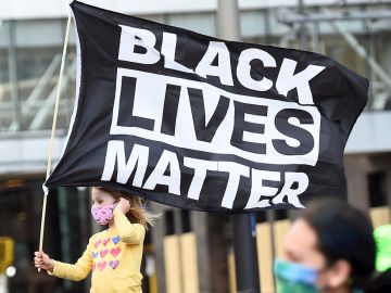 Una niña sostiene una bandera en la que se lee "Black Lives Matter", el eslogan utilizado en las protestas motivadas por la muerte de George Floyd