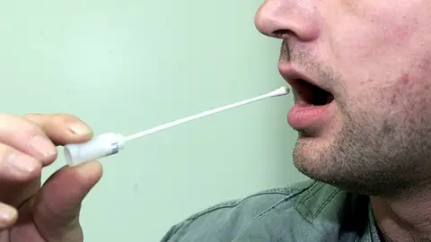 Un hombre se somete a un test de saliva Un hombre se somete a un test de saliva