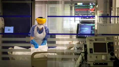 Una sanitaria atiende a un paciente en la UCI Una sanitaria atiende a un paciente en la UCI