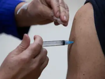 Sanitario administrando una dosis de la vacuna contra el coronavirus Sanitario administrando una dosis de la vacuna contra el coronavirus