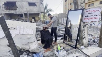La emotiva imagen de un barbero palestino que atiende a sus clientes entre los escombros