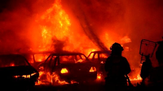 Un bombero intenta apagar un incendio de un estacionamiento del tr&aacute;nsito tras una nueva jornada de protesta en Colombia.