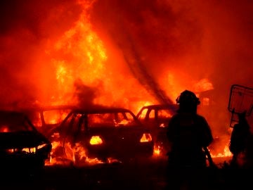 Un bombero intenta apagar un incendio de un estacionamiento del tránsito tras una nueva jornada de protesta en Colombia.