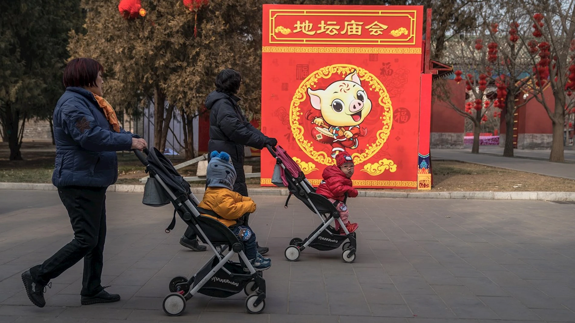 China permitirá tener 3 hijos por familia// Dos mujeres pasean con sus hijos por un parque de Pekín.