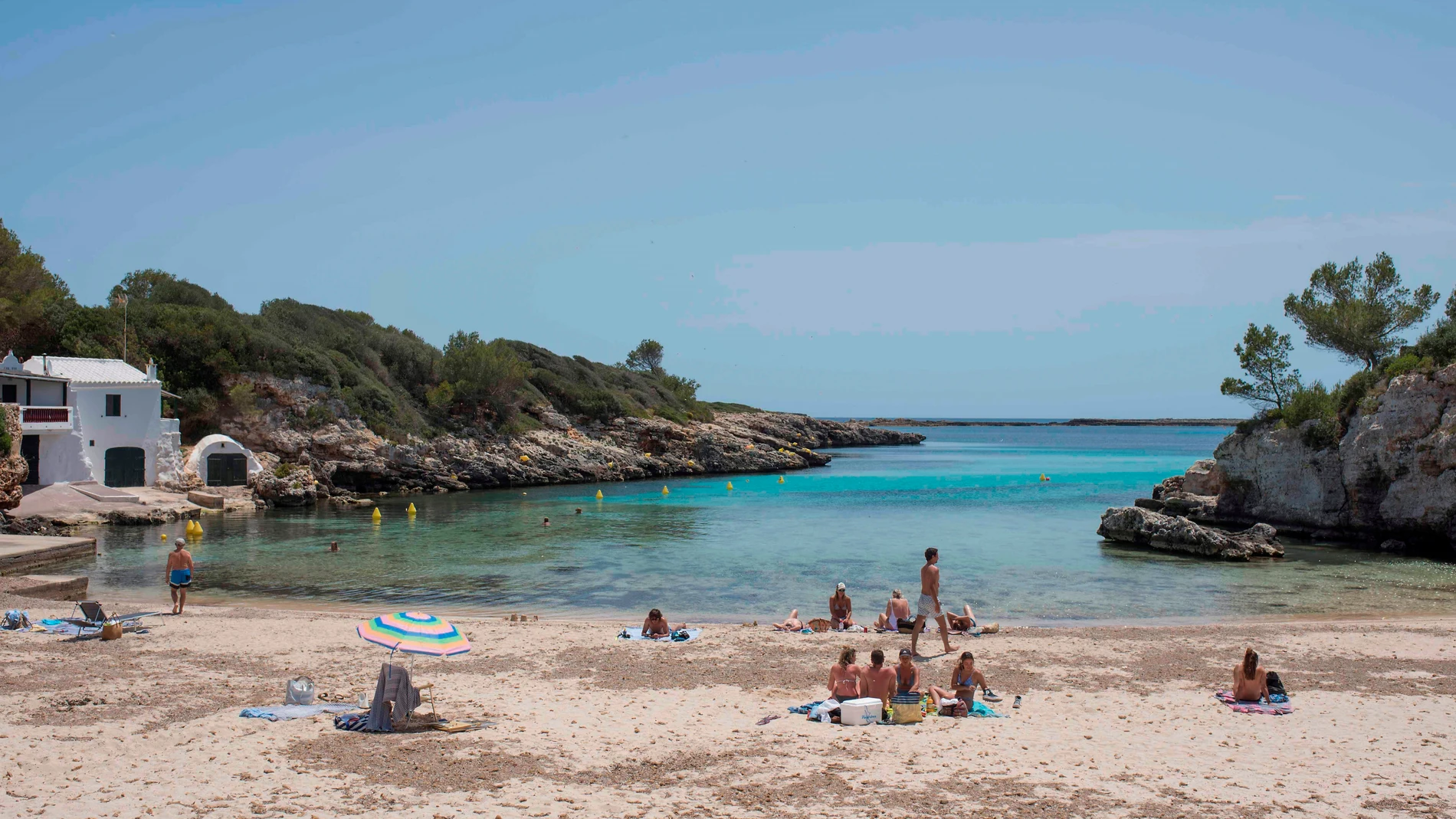 Turistas toman el sol en la playa de Binisafúller, en Menorca