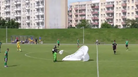 Un paracaídista aterriza en un campo de fútbol y el árbitro le saca una tarjeta amarilla Un paracaídista aterriza en un campo de fútbol y el árbitro le saca una tarjeta amarilla