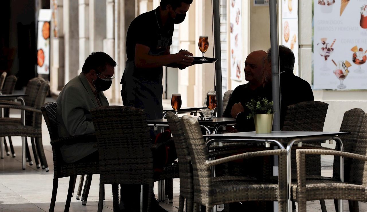 Un camarero atiende una mesa en una terraza del centro de Valencia Un camarero atiende una mesa en una terraza del centro de Valencia