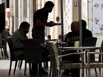 Un camarero atiende una mesa en una terraza del centro de Valencia Un camarero atiende una mesa en una terraza del centro de Valencia