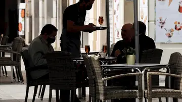Un camarero atiende una mesa en una terraza del centro de Valencia Un camarero atiende una mesa en una terraza del centro de Valencia