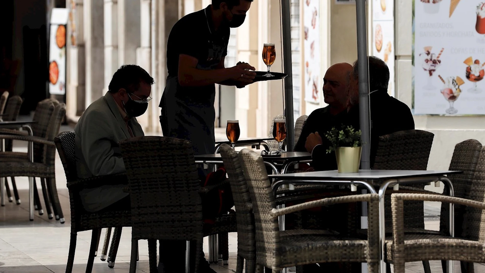 Un camarero atiende una mesa en una terraza del centro de Valencia