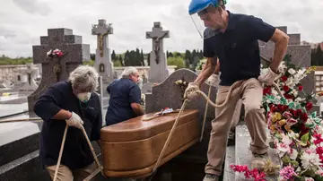 Trabajadores del cementerio de La Almudena entierran el ataúd de Manuela Revuelta. Manuela, 94 años, falleció el 4 de abril en una residencia de ancianos, a consecuencia de la covid-19. Madrid, 7 de abril, 2020. (© Alejandro Martinez Vélez)