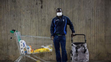 Wade Ngagne, de 35 años, recoge alimentos en el parking del estadio deportivo de Badalona donde la Cruz Roja reparte alimentos varios días en la semana. La pandemia lo ha dejado sin trabajo. Vive con su tía y dos personas más y sobrevive gracias a la ayuda de Cruz Roja y de su tía. El coronavirus se ha convertido en un tsunami que está arrasando todo lo que encuentra a su paso. Miles de personas se han visto en situación de pobreza en cuestión de pocos meses y las organizaciones humanitarias se están viendo sobrepasadas por el aluvión de peticiones de alimentos y artículos de primera necesidad. Las colas del hambre invaden sin remedio las ciudades. Una imagen que se ha convertido en algo habitual. Badalona, 19 de mayo de 2020 (© Nuria López Torres)