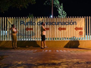 Gente esperando a ser vacunada de noche en el Zendal