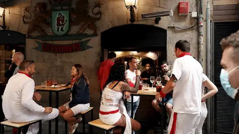 Un grupo de personas almuerzan en una bar de la calle Estafeta este martes, 6 de julio, cuando debería lanzarse el tradicional chupinazo que diera inicio a las fiestas de San Fermin 2021 suspendidas por segundo año consecutivo por la pandemia de coronavirus Un grupo de personas almuerzan en una bar de la calle Estafeta este martes, 6 de julio, cuando debería lanzarse el tradicional chupinazo que diera inicio a las fiestas de San Fermin 2021 suspendidas por segundo año consecutivo por la pandemia de coronavirus