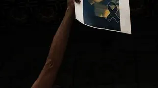 Un joven levanta una foto de Samuel Un joven levanta una foto de Samuel