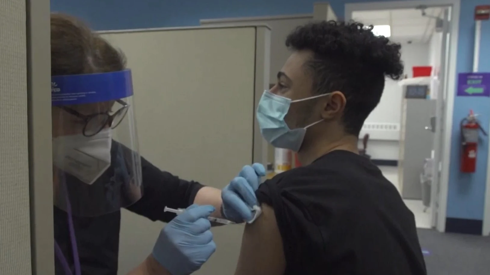 Una sanitaria administra una vacuna contra el coronavirus a un joven