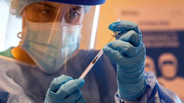 Una sanitaria prepara una vacuna contra el coronavirus