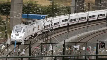 Un tren alvia similar al accidentado en Angrois, pasa por la curva donde permanecen objetos colocados en memoria de las víctimas mortales Un tren alvia similar al accidentado en Angrois, pasa por la curva donde permanecen objetos colocados en memoria de las víctimas mortales