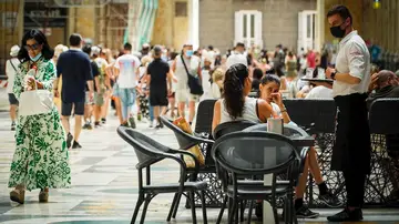 Un camarero atiende a los clientes en la terraza de un restaurante en Nápoles, Italia. Un camarero atiende a los clientes en la terraza de un restaurante en Nápoles, Italia.
