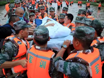 Miembros de los servicios de emergencia evacuan a los residentes de Zhengzhou (China), este jueves. Miembros de los servicios de emergencia evacuan a los residentes de Zhengzhou (China), este jueves.