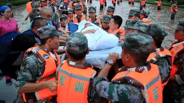 Miembros de los servicios de emergencia evacuan a los residentes de Zhengzhou (China), este jueves.