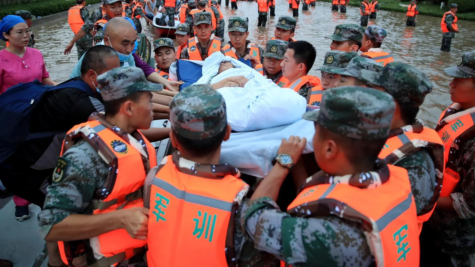 Miembros de los servicios de emergencia evacuan a los residentes de Zhengzhou (China), este jueves.