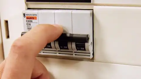Precio de la luz: Imagen de una persona pulsando un interruptor Precio de la luz: Imagen de una persona pulsando un interruptor