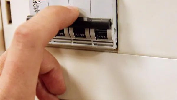 Precio de la luz: Imagen de una persona pulsando un interruptor Precio de la luz: Imagen de una persona pulsando un interruptor